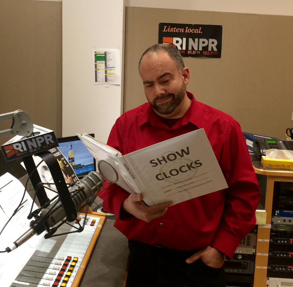 Picture of Aaron Read looking unamused as he browses a file folder labeled SHOW CLOCKS.